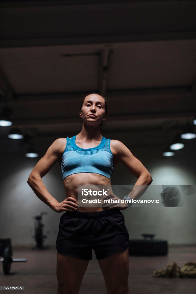 Never let the comfort zone become your norm Confident young woman posing for a photo in sports clothing while standing in the gym 20-29 Years Stock Photo
