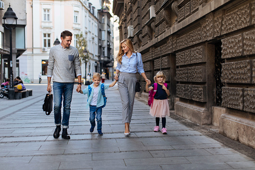 Photo of a young family of four walking around town during the day