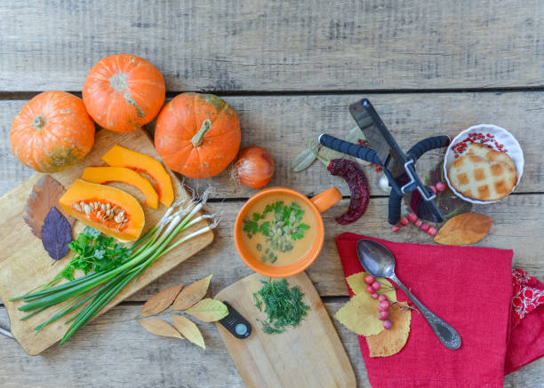 istock Pumpkin soup on wooden background, vintage. Hands, cooking process. 1277294083