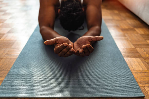 You look your best when you are at peace Cropped shot of an unrecognizable man on yoga mat and meditating alone in his home. meditation hands stock pictures, royalty-free photos & images