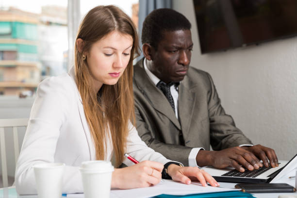 istock Male and female colleagues working  with laptop and documents at table 1277295755