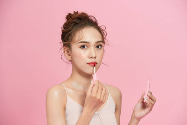 istock Cute girl applying lip gloss 1277298698