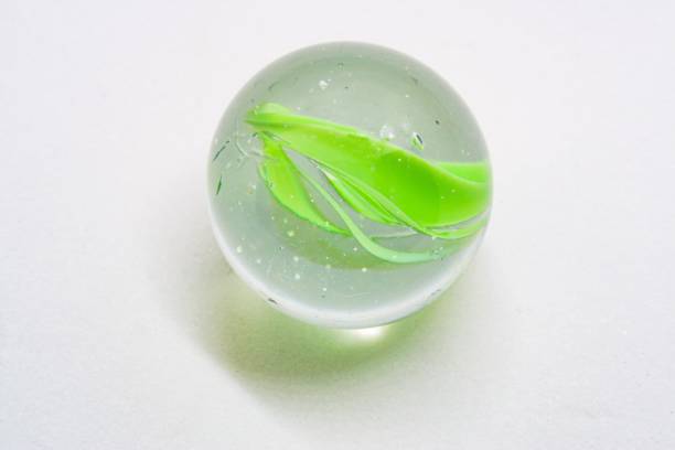 istock Macro closeup of green marble in white background studio shot 1277299939