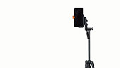 Mobile phone stuck on camera stand isolated from white background. Concept of live line.