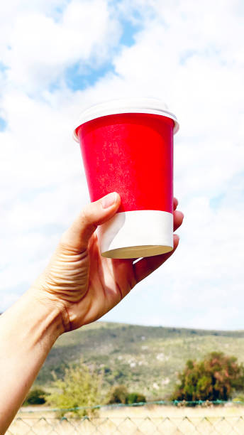 istock young woman holding  red coffee  cup,  cloud backgrounds 1277301779