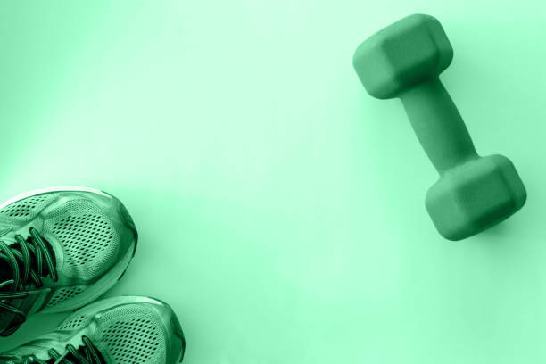 istock sneakers and dumbbell toned in neo mint, good background, sport concept, enough empty space for text, banner. 1277302549