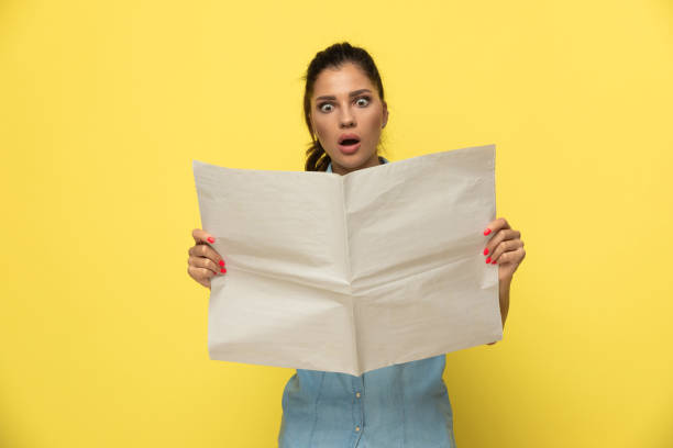 istock Amazed casual woman reading newspaper and gasping 1277303931