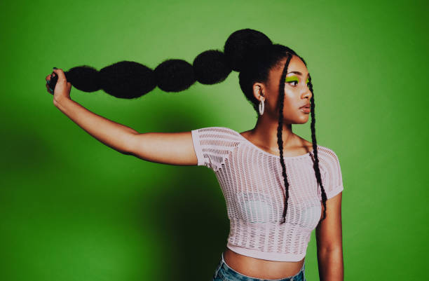 Get on the trend Shot of a young woman posing against a green background with a trendy hairstyle black woman hair extensions stock pictures, royalty-free photos & images