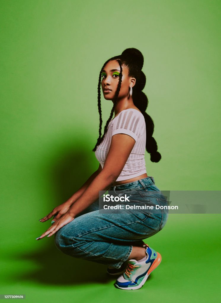 Your style is what sets you apart Shot of a young woman posing against a green background with a trendy hairstyle Women Stock Photo