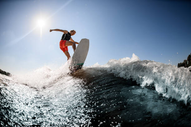 istock Active man rides on surf style wakeboard on the wave 1277310758