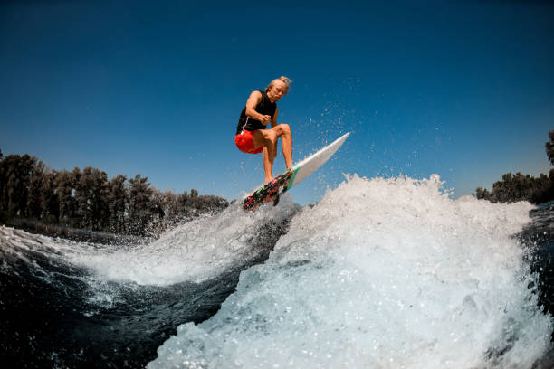 istock view of athletic man on surf style wakeboard jumping over splashing wave 1277311361