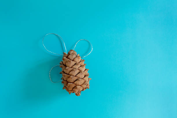 Christmas composition with a pine cone on a blue background. Postcard, Flat Lay. New Year, minimalism, top view, copy space.