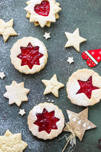 istock Traditional Linzer Christmas cookies with raspberry jam on green stone background. Top view. Flat lay. Festive decoration. 1277312927