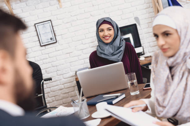 Arab woman sitting at a laptop and work. stock photo