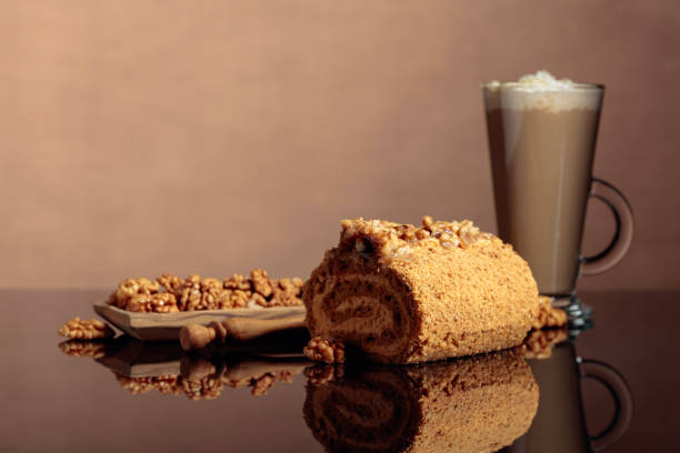 Walnut cake and coffee latte with cream on a reflective background. Copy space.