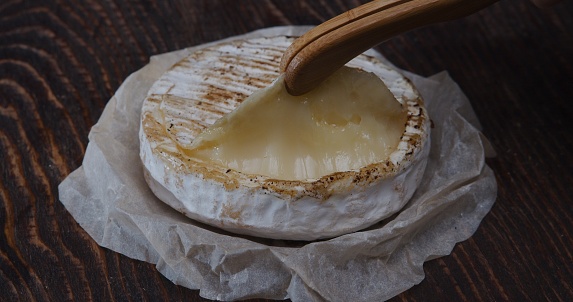 Removing the top crust of camembert. Extreme close-up