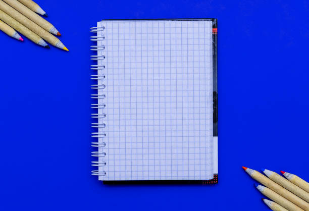 istock Notepad and color pencils on a blue background. Flat lay, copy space, top view. Business, home schooling, drawing. 1277319880