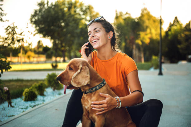 istock Woman using cell phone sitting outside near her dog 1277319885