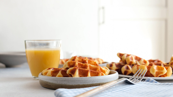 Belgian waffles and orange juice breakfast on a table