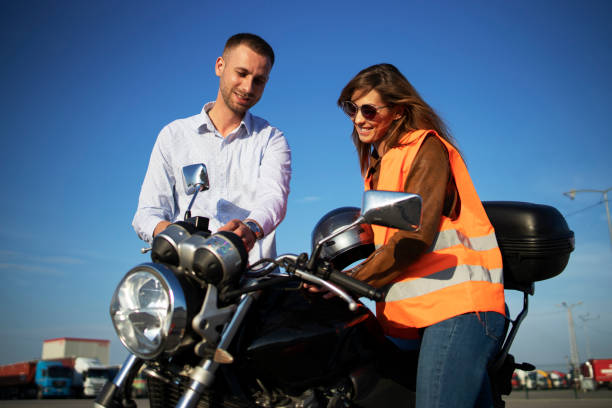 Driving instructor showing motorcycle commands and dashboard to the inexperienced student. Learning to ride motorcycle.