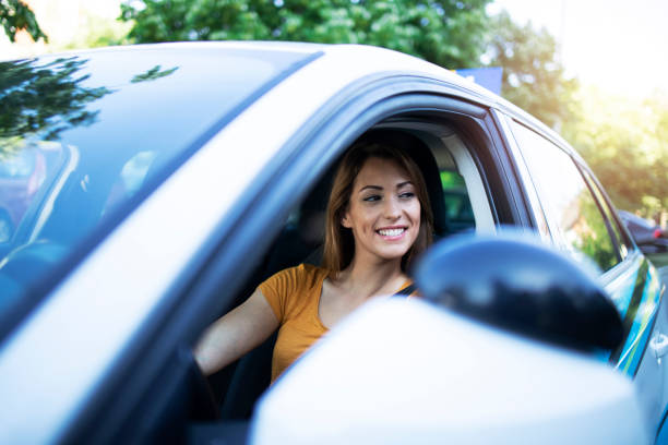 istock Beautiful brunette woman driving a car. 1277325021