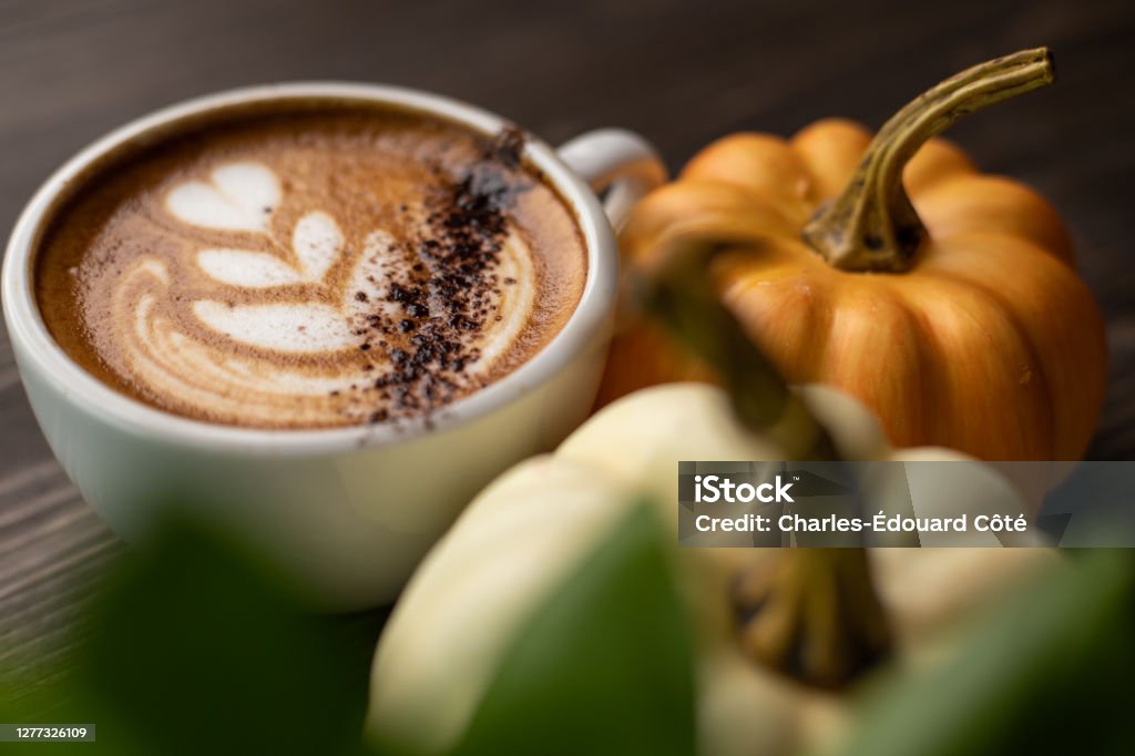 Pumpkin spice latte on a wooden background Pumpkin spice latte on a wooden background with copy space with latte art in the coffee Pumpkin Spice Latte Stock Photo