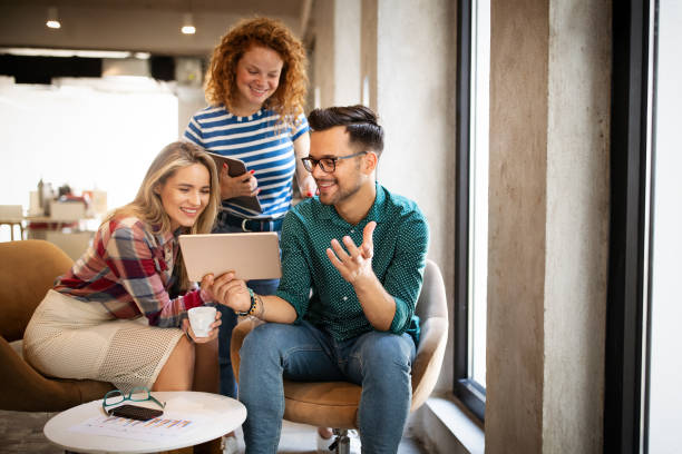 istock Smiling business people talking and working together in bright office 1277327878