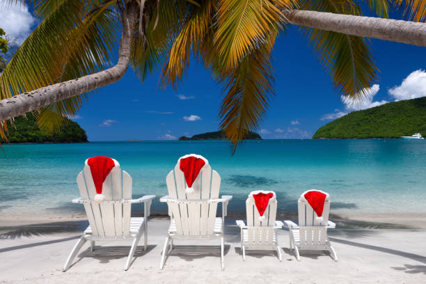 istock Adirondack chairs and palm trees with Christmas hats on a tropical beach 1277331880