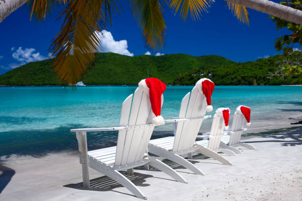 istock Adirondack chairs and palm trees with Christmas hats on a tropical beach 1277331888