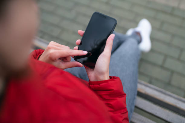 istock Woman sits on a bench and uses smartphone 1277332997