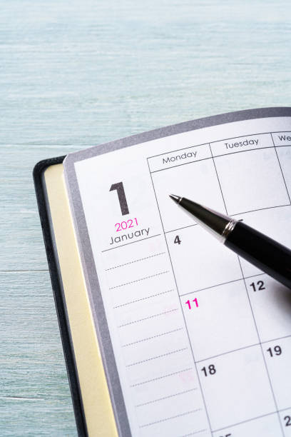 istock 2021 Notebook and pen on wooden table (2021 schedule book) 1277333284