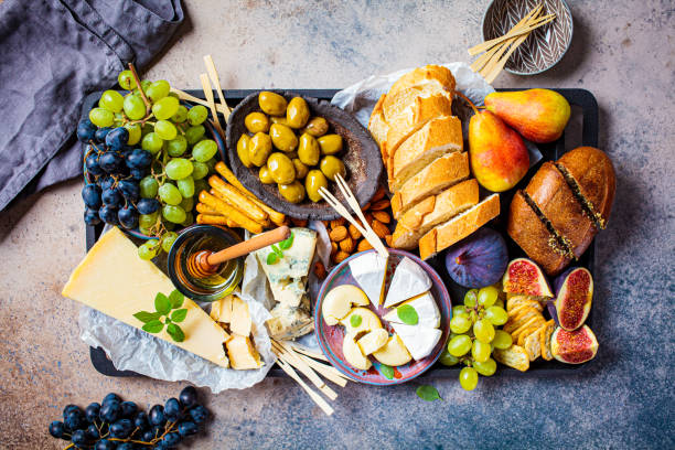 istock Cheese plate served with fruits, honey and snacks, top view. Assorted cheese background. 1277334219