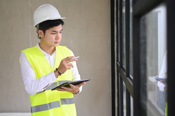 istock Young architect with helmet and tablet indoor at construction site, checklist concept. 1277334311