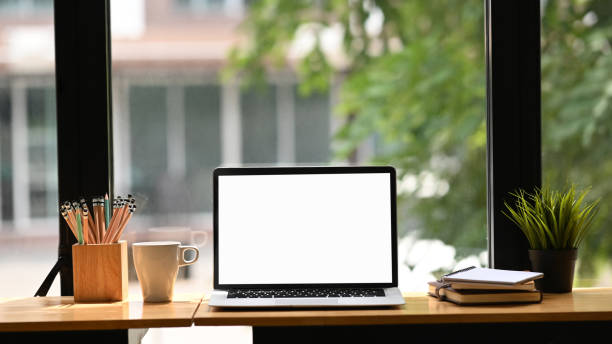 istock Workspace laptop computer with empty screen and office supplies on wooden table bar. 1277334534