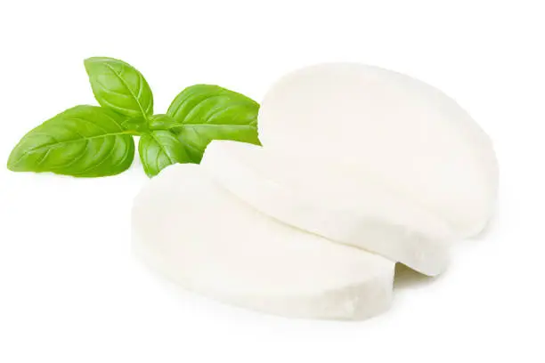 Photo of Mozzarella cheese with basil leaves isolated on white background