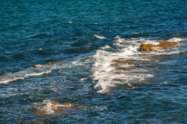 Waves crash on rocks at Peveril Point in Swanage
