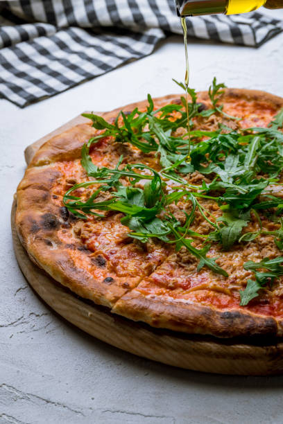 istock Pizza with tuna and aragula on white concrete table 1277337444