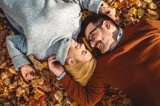 istock Young couple having fun and lying down on leaves 1277339021