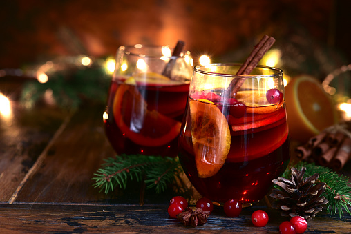 Red spicy christmas mulled wine with cranberries, apple and orange .