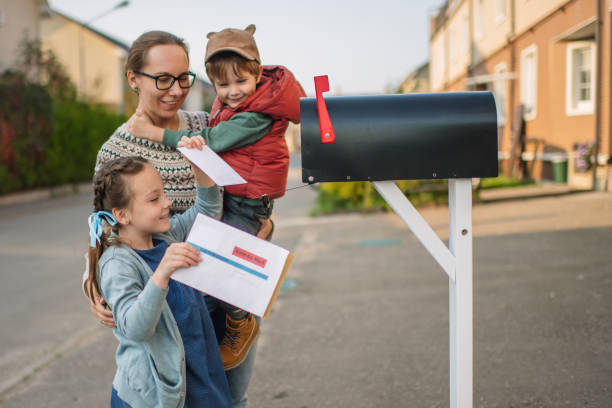 istock Family sending or receiving mail with voting ballot using mailbox near house 1277341396