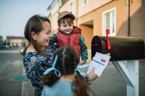 rodzina wysyłająca lub odbierająca pocztę ze skrzynką pocztową do głosowania w pobliżu domu - voting election politics little girls zdjęcia i obrazy z banku zdjęć