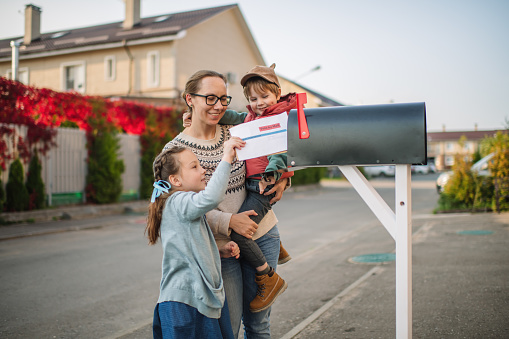 Hispanic Woman Checking Mailbox Smiling at Camera