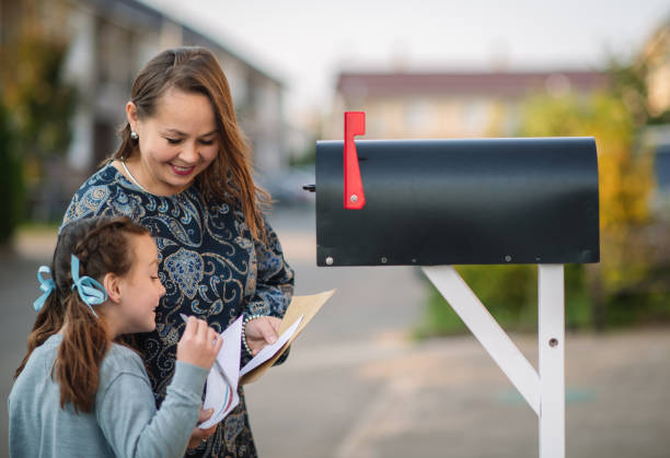 rodzina wysyłająca lub odbierająca pocztę ze skrzynką pocztową w pobliżu domu - voting election politics little girls zdjęcia i obrazy z banku zdjęć