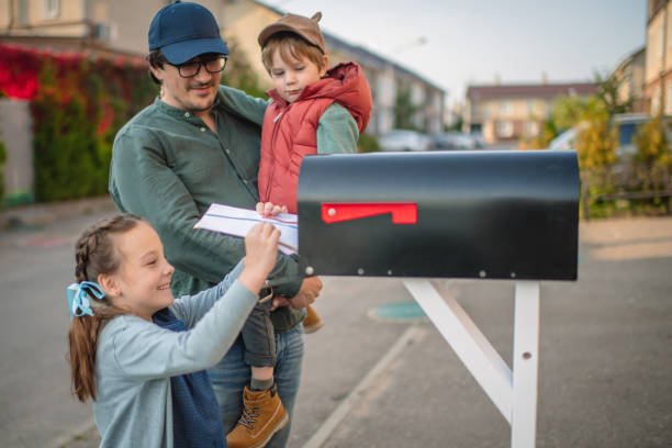 rodzina wysyłająca lub odbierająca pocztę ze skrzynką pocztową w pobliżu domu - voting election politics little girls zdjęcia i obrazy z banku zdjęć