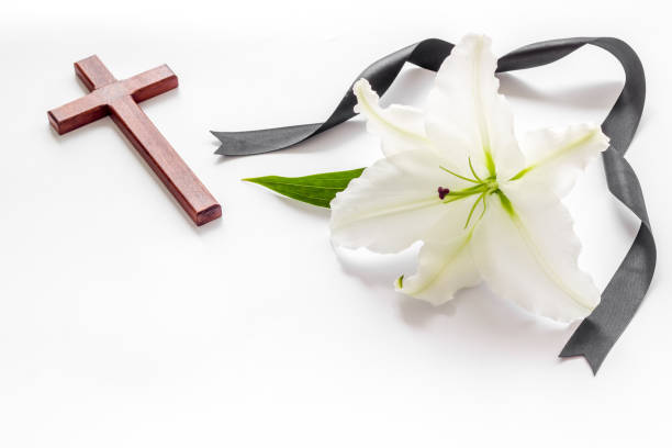 istock White lily with cross and black ribbon. Funeral concept 1277343520