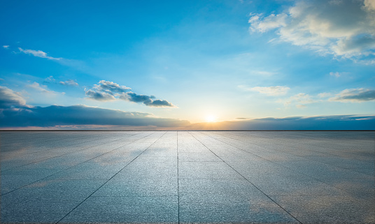 Under a clear sky, the setting sun after sunset shines on the marble floor