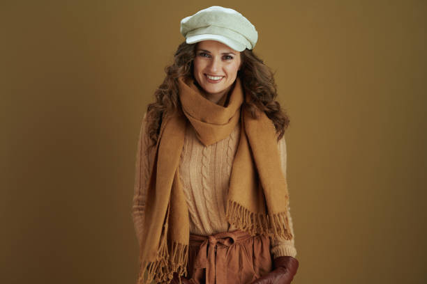 istock smiling trendy female in sweater isolated on bronze background 1277346887