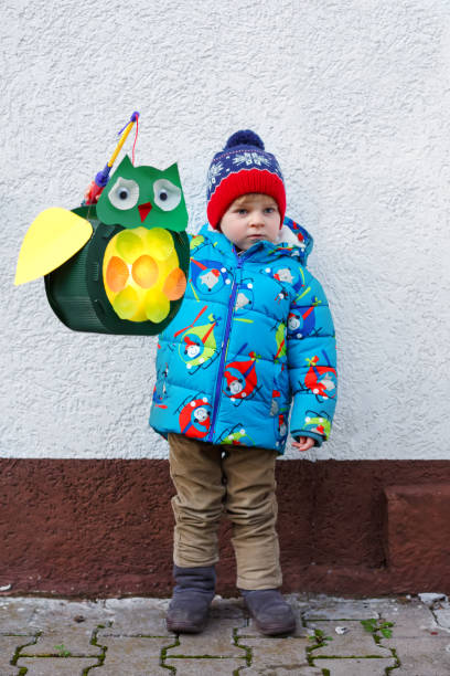 istock Little kid boy holding selfmade lanterns for a Halloween or St. Martin procession. Beautiful healthy cute child happy about children and family parade in kindergarten. German tradition Martinsumzug 1277347199