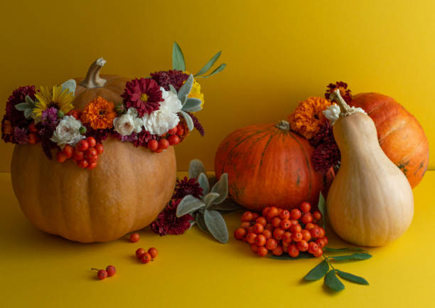istock Fresh pumpkin with flowers on yellow background. 1277348349