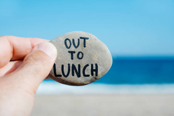 istock man on the beach and text out to lunch in a stone 1277348812